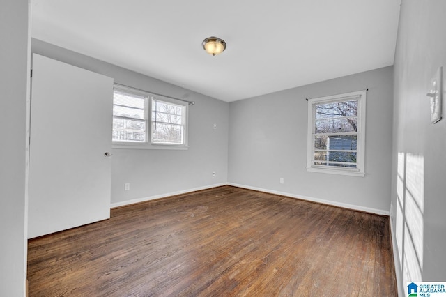 unfurnished room with dark wood-type flooring