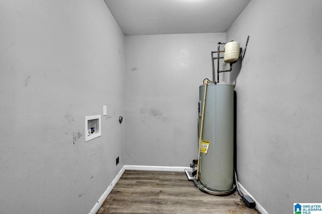 clothes washing area with washer hookup, hardwood / wood-style flooring, and water heater