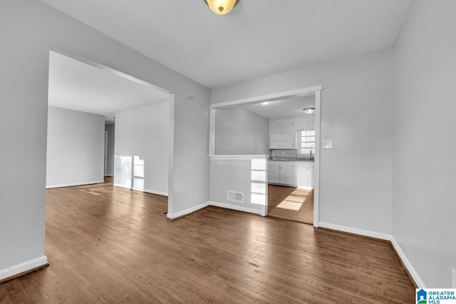 spare room with hardwood / wood-style flooring and sink