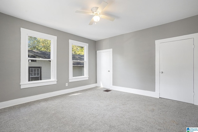 carpeted spare room featuring ceiling fan