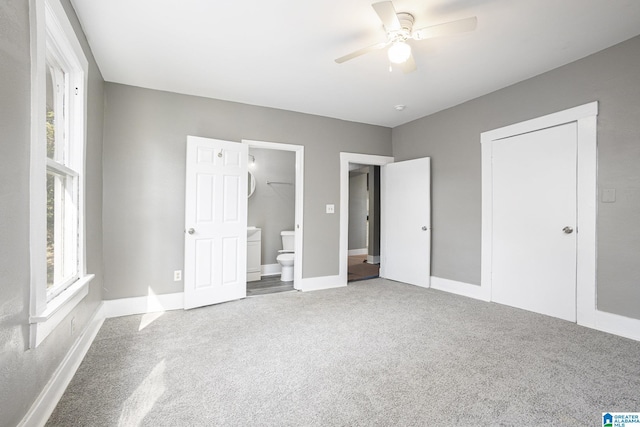 unfurnished bedroom featuring carpet flooring, connected bathroom, a closet, and ceiling fan