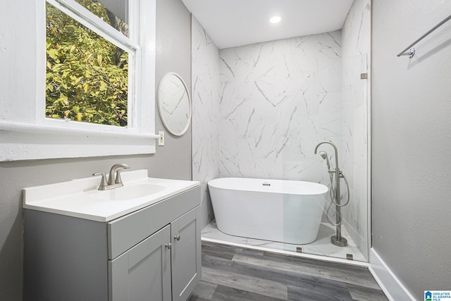 bathroom with hardwood / wood-style floors, vanity, and a bath