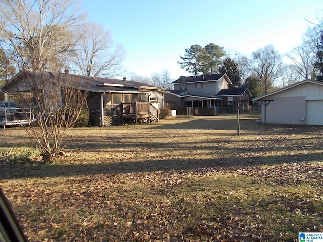 view of yard with a garage, an outdoor structure, and a deck