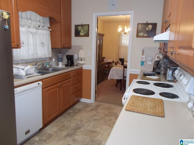 kitchen featuring sink, hanging light fixtures, ventilation hood, a chandelier, and white appliances