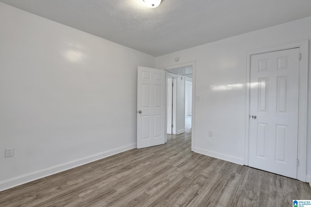 unfurnished bedroom featuring light hardwood / wood-style floors and a textured ceiling