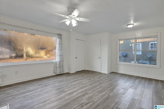 spare room with ceiling fan, plenty of natural light, and light hardwood / wood-style floors