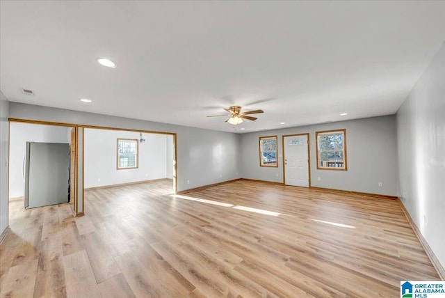 unfurnished room with ceiling fan and light wood-type flooring