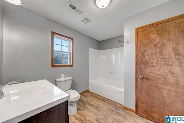 full bathroom with hardwood / wood-style floors, vanity, toilet, and shower / tub combination