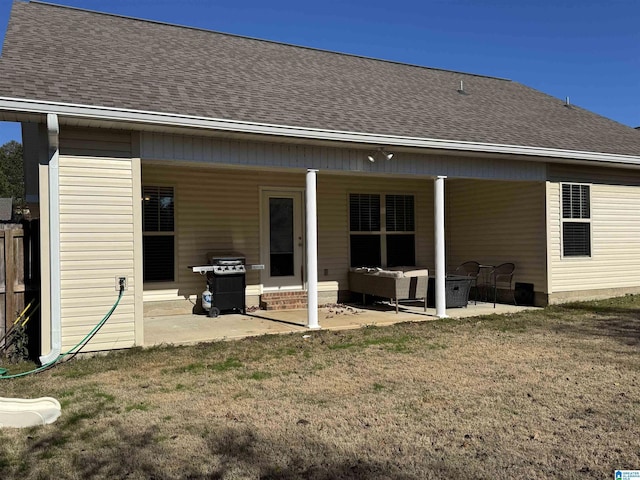 back of house featuring a lawn, an outdoor living space, and a patio