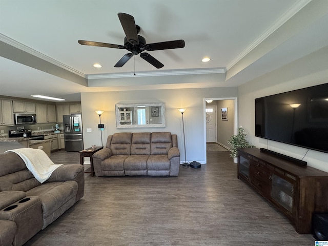 living room featuring dark hardwood / wood-style flooring, ceiling fan, a raised ceiling, and crown molding