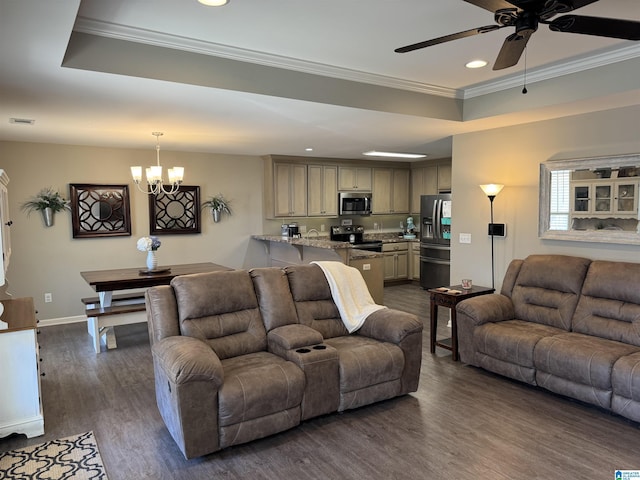 living room featuring ceiling fan with notable chandelier, dark hardwood / wood-style flooring, a tray ceiling, and crown molding