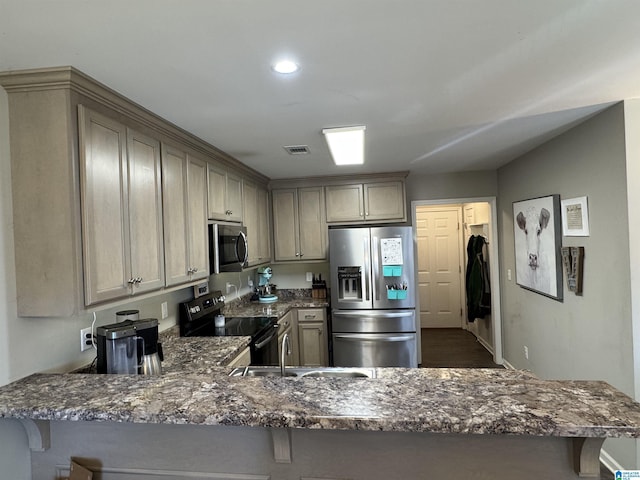 kitchen with kitchen peninsula, a kitchen bar, stainless steel appliances, and sink