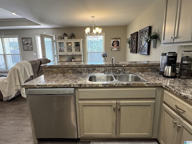 kitchen featuring stainless steel dishwasher, sink, decorative light fixtures, a chandelier, and dark hardwood / wood-style floors