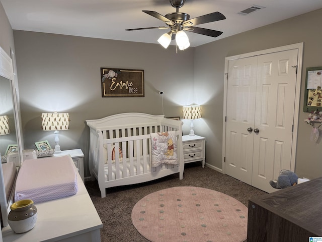 carpeted bedroom featuring a closet, a nursery area, and ceiling fan