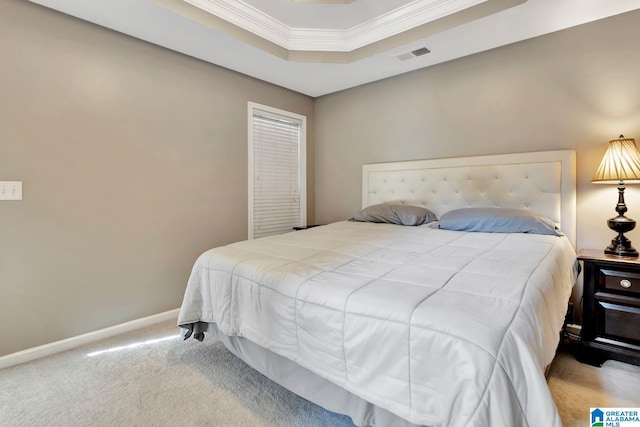 bedroom with carpet, ornamental molding, and a tray ceiling