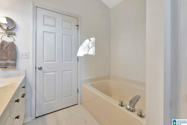 bathroom with vanity, a tub, and tile patterned floors