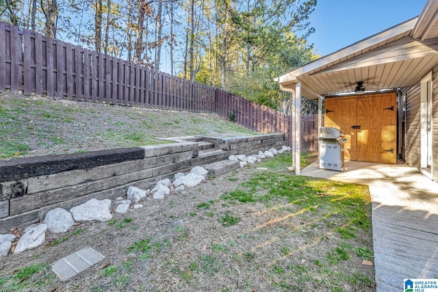 view of yard with ceiling fan and a patio