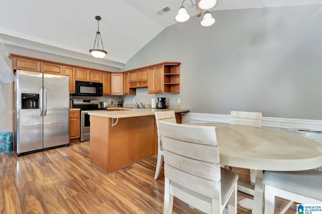 kitchen with a breakfast bar area, appliances with stainless steel finishes, kitchen peninsula, pendant lighting, and sink