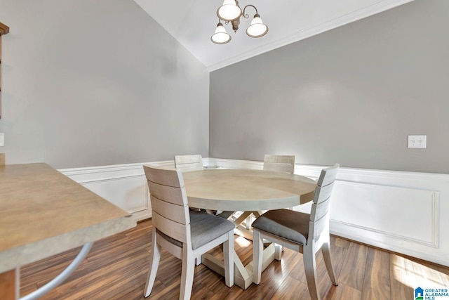 dining room featuring lofted ceiling, dark hardwood / wood-style flooring, and an inviting chandelier