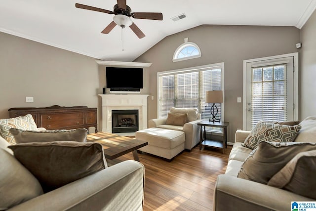 living room featuring ceiling fan, ornamental molding, vaulted ceiling, and dark hardwood / wood-style floors