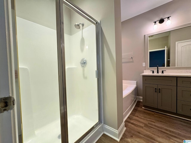 bathroom with vanity, hardwood / wood-style flooring, and separate shower and tub