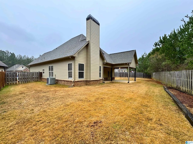 back of property featuring a lawn, central air condition unit, and a patio