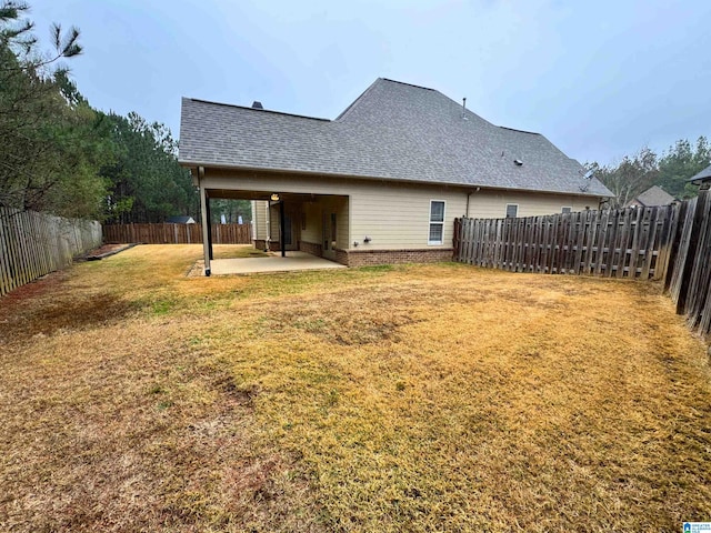 rear view of house featuring a patio area and a lawn