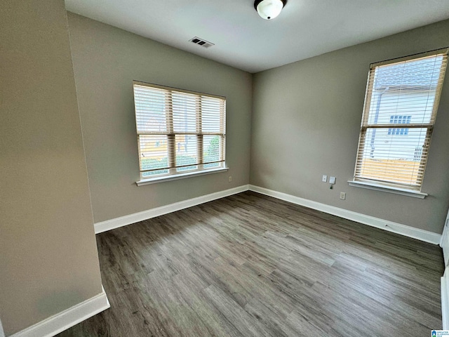 spare room featuring dark hardwood / wood-style flooring and a wealth of natural light