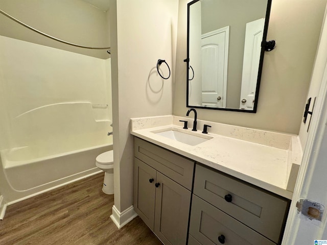 full bathroom with toilet, hardwood / wood-style floors, vanity, and tub / shower combination