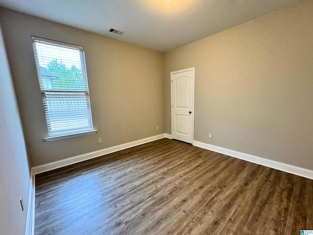 empty room with dark hardwood / wood-style flooring