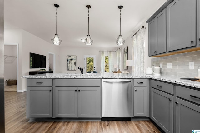 kitchen with sink, light hardwood / wood-style flooring, stainless steel dishwasher, gray cabinets, and light stone countertops