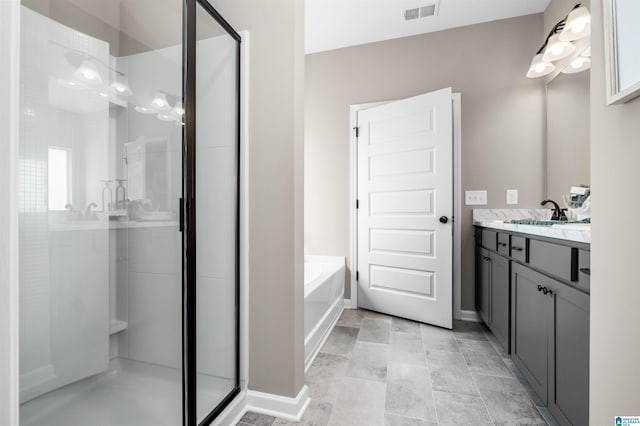 bathroom with vanity and shower with separate bathtub