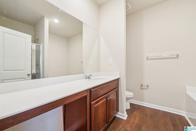 bathroom featuring hardwood / wood-style floors, vanity, toilet, and walk in shower