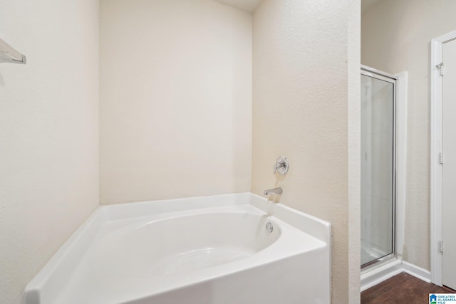 bathroom with shower with separate bathtub and hardwood / wood-style flooring