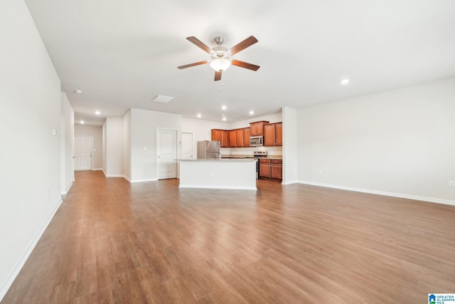 unfurnished living room featuring light wood-type flooring and ceiling fan