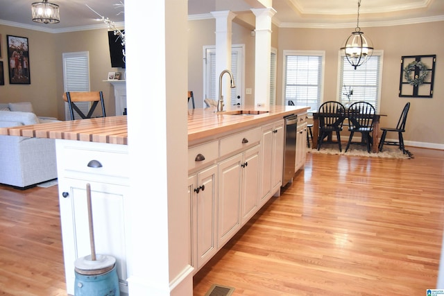 kitchen featuring white cabinets, butcher block counters, hanging light fixtures, and an inviting chandelier