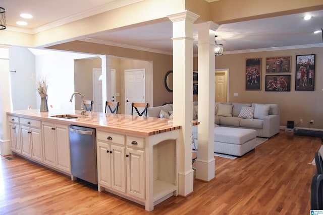 kitchen featuring butcher block countertops, sink, stainless steel dishwasher, and ornamental molding