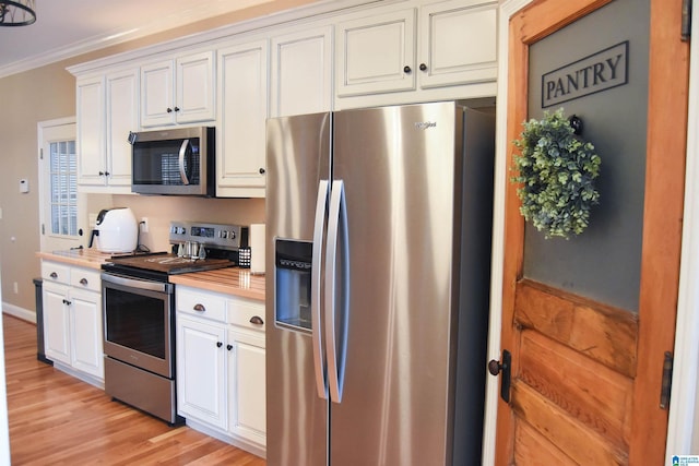 kitchen featuring white cabinetry, crown molding, stainless steel appliances, and light wood-type flooring