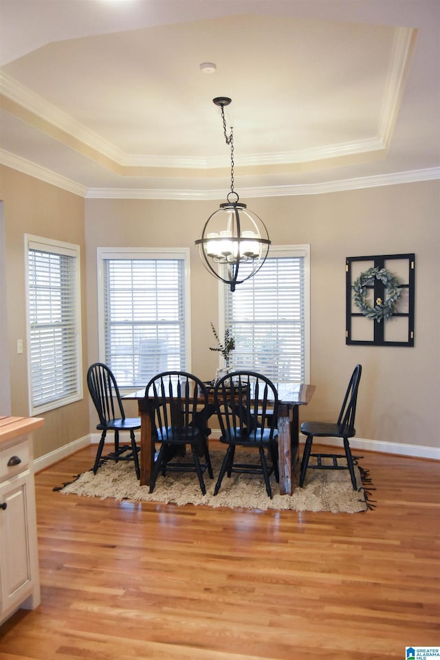 dining space featuring a chandelier, plenty of natural light, light hardwood / wood-style flooring, and a tray ceiling