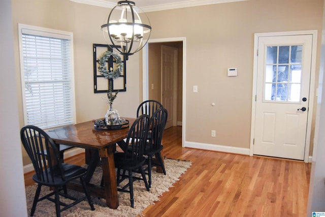 dining room featuring light hardwood / wood-style flooring, an inviting chandelier, and crown molding