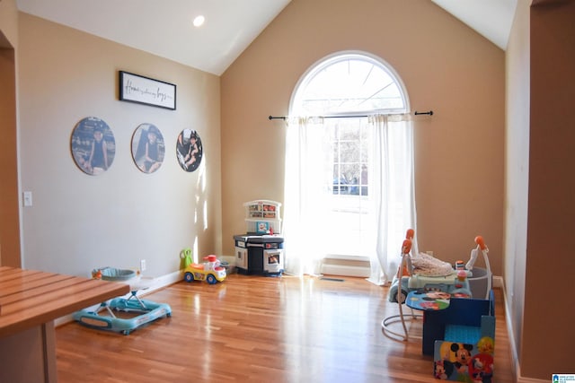 game room with vaulted ceiling and hardwood / wood-style flooring