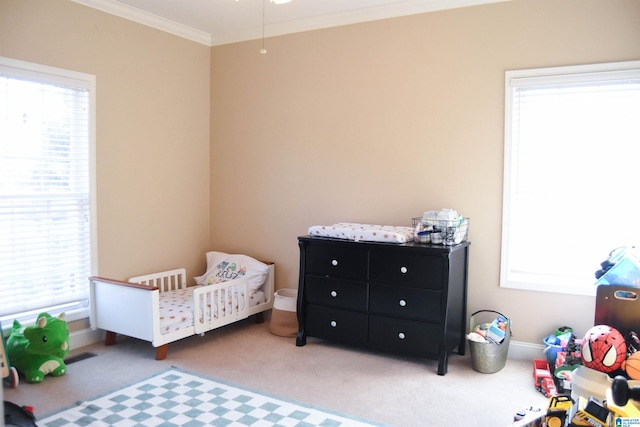 carpeted bedroom with a crib and crown molding