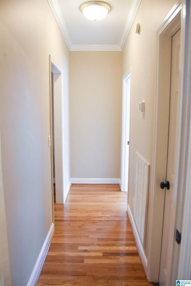 hall with wood-type flooring and ornamental molding