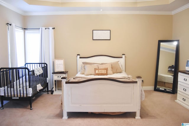 bedroom with crown molding, a raised ceiling, and light carpet