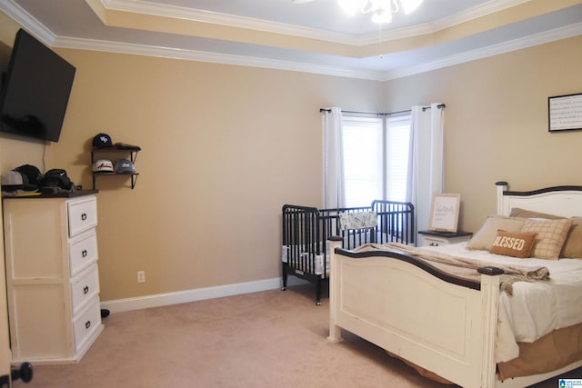 carpeted bedroom with a tray ceiling and crown molding