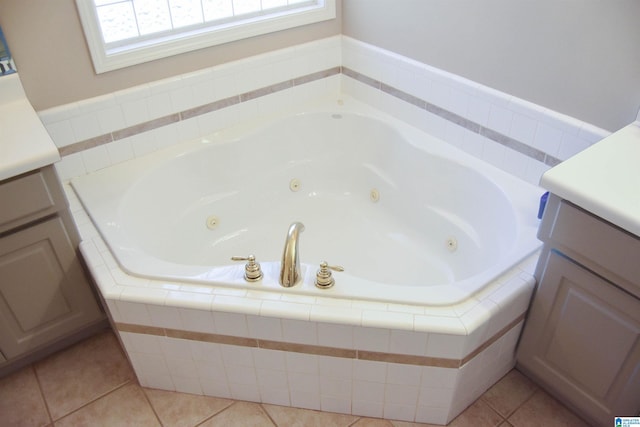 bathroom featuring tile patterned floors, vanity, and tiled bath