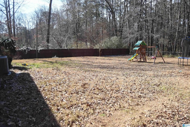 view of yard with a playground, central AC unit, and a trampoline