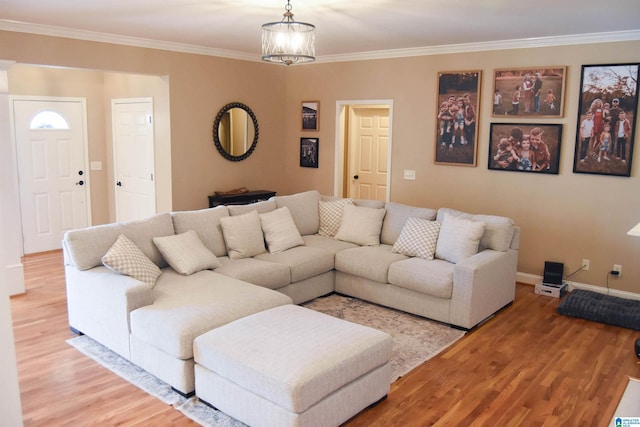 living room featuring a chandelier, wood-type flooring, and ornamental molding