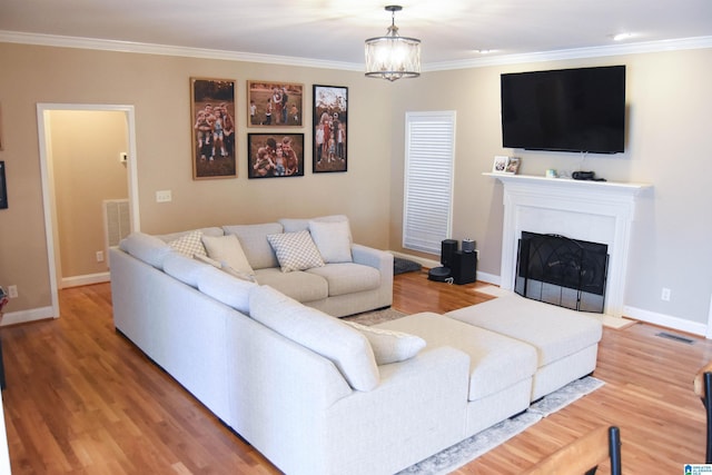 living room featuring wood-type flooring, crown molding, and an inviting chandelier