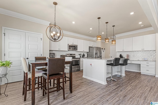 dining space featuring light hardwood / wood-style flooring, a chandelier, and ornamental molding